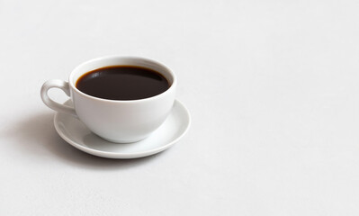 Cup of hot coffee on a white concrete background. Black coffee in a small cup. Copy space.