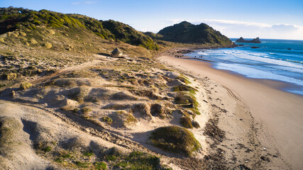 Playa 2 algunas dunas, islotes, olas y cerrando con un atardecer. Sector Estaquilla, Patagonia norte de Chile
