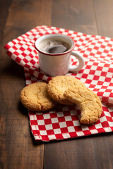 Homemade crunchy cookies and a espresso coffee cup on wooden table