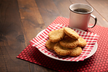 Homemade crunchy cookies and a american coffee cup on broun wooden rustic table