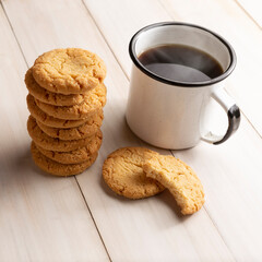Homemade crunchy cookies and a coffee cup on white wooden rustic table