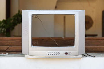 An old silver TV without a CRT near an abandoned hotel. Vintage TVs 1980s 1990s 2000s. 
