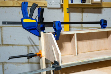 Heavy duty clamps holding a woodworking project after gluing up