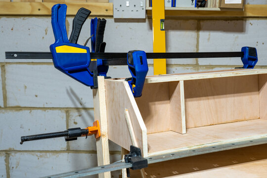 Heavy duty clamps holding a woodworking project after gluing up