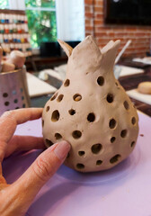 we sculpt from clay in a pottery workshop, creativity with our own hands, a clay vase for dry plants in the shape of a pomegranate