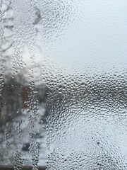 view from the window wet glass covered with wet flowing water, snow melts water drops