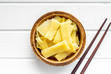 Sliced canned bamboo shoots in wooden bowl.
