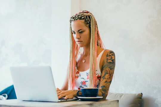 Young girl using laptop and smartphone in cafe - Powered by Adobe