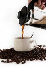 Pouring coffee on a white coffee mug on background
