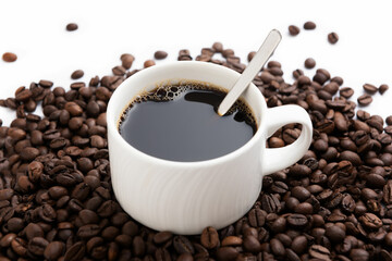 White coffee mug with spoon on coffee background