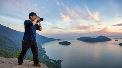 Adventure Photographer Hiking and taking pictures of Canadian mountain landscape during colorful sunset. Tunnel Bluffs Hike, North of Vancouver, BC, Canada.