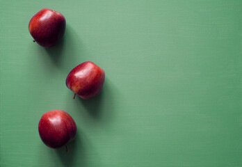 fresh red apples, shiny, natural light, green background, space for text, photo taken from above