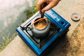 Top view of a kettle with coffee on a mobile camping little stove.