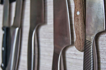 Sharp kitchen knives attached to a magnetic knife holder