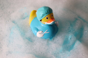 Quietscheentchen im Badeschaum. Swimming duck.