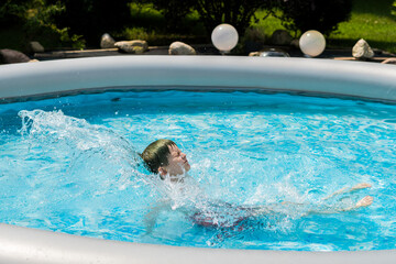 boy in pool splashing water