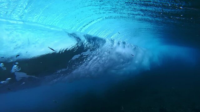 Wave rolls and breaks. Underwater view of the ocean wave rolling and breaking over the coral reef