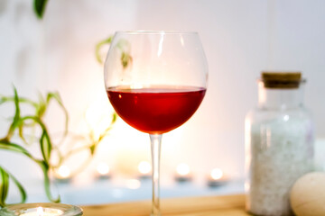 Spa-beauty salon, wellness center. Spa treatment aromatherapy for the female body in the bathroom with a glass of wine, with candles, oils and salt