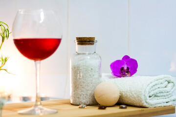 Spa-beauty salon, wellness center. Spa treatment aromatherapy for the female body in the bathroom with a glass of wine, with candles, oils and salt