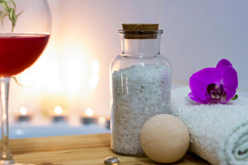 Fototapeta na wymiar Spa-beauty salon, wellness center. Spa treatment aromatherapy for the female body in the bathroom with a glass of wine, with candles, oils and salt