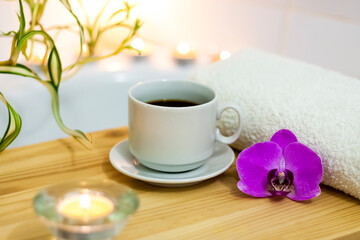 Obraz na płótnie Canvas Spa-beauty salon, wellness center. Aromatherapy spa treatment for the female body in the bathroom with a cup of coffee, candles, oils and salt.