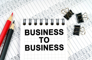 On the table are reports, pencils and a notebook with the inscription - BUSINESS TO BUSINESS
