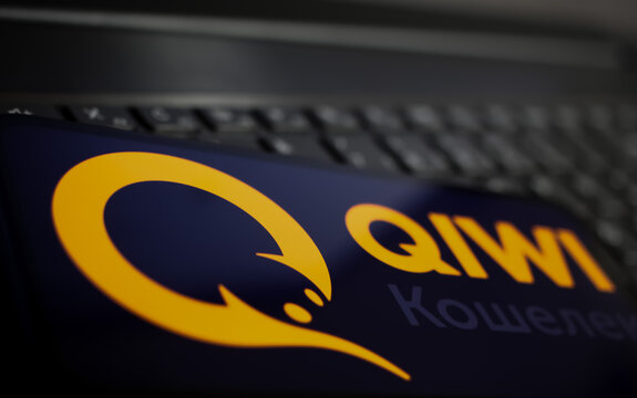 Viersen, Germany - June 1. 2021: Closeup of mobile phone screen with logo lettering of russian online payment service qiwi on computer keyboard