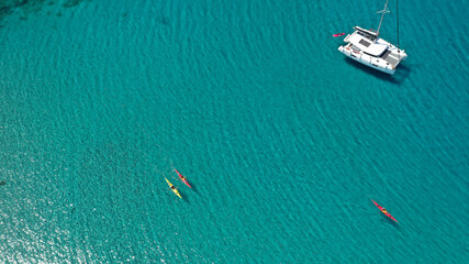 Aerial drone photo of team of young women practice on sport kayak in tropical exotic bay with emerald crystal clear sea