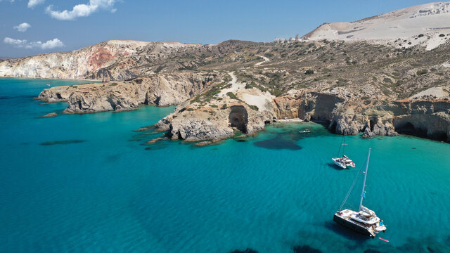Aerial drone photo of beautiful volcanic emerald paradise bay and sandy beach of Tsigrado below white rock with perlite mine, Milos island, Cyclades, Greece