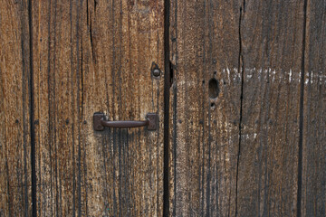 Antique wooden door with rusted hardware