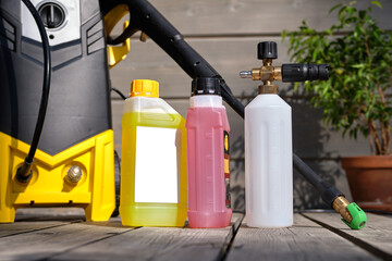 mini household high-pressure washer for washing a car against the background of a gray house and a...