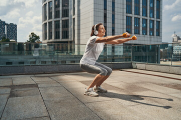Smiling elderly woman doing training with dumbbells