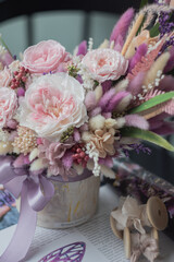 Bouquet with roses, hydrangea and a and dry lagurus. Stabilized flowers in pink color in a ceramic vase at home on the dressing table.
