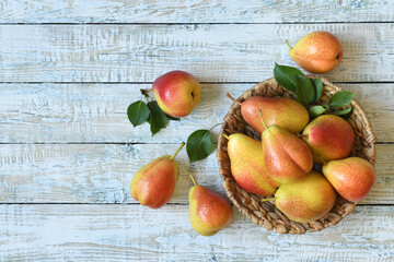 Fresh pears in a basket on a white wooden table. Top view.