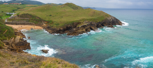 Fototapeta na wymiar Vistas panorámicas espectaculares de la Playa de Santa Justa, con el mar de color verde y turquesa en Cantabria, España, verano de 2020
