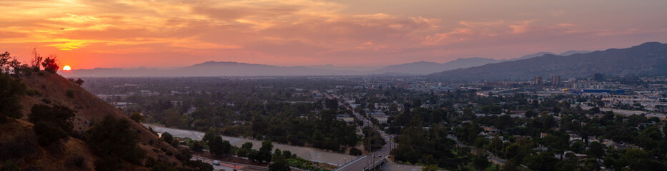 Dramatic sunset over the city of Burbank with a plane flying over.