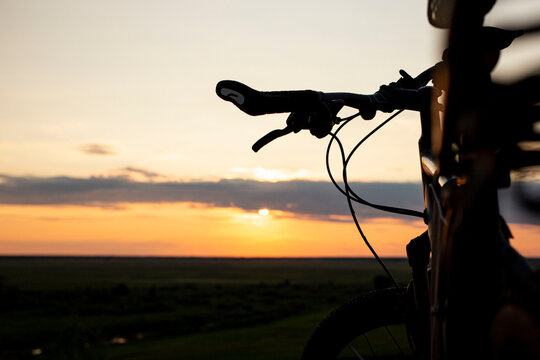 sunset photographed through bike details, front and background blurred with bokeh effect