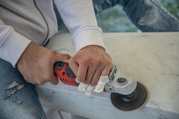 Artist cutting marble stone with angle sander and diamond disc