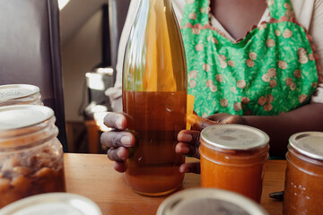 Home chef labeling a bottle of homemade fruit liquor 