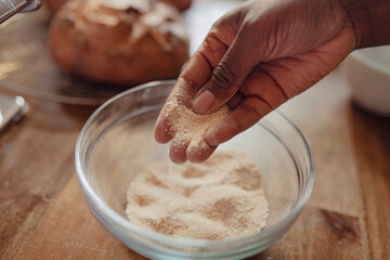 Flour being sifted by hand into a mixing bowl