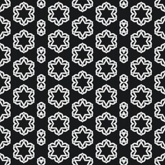 Seamless pattern of black and white geometrical patterns on black background