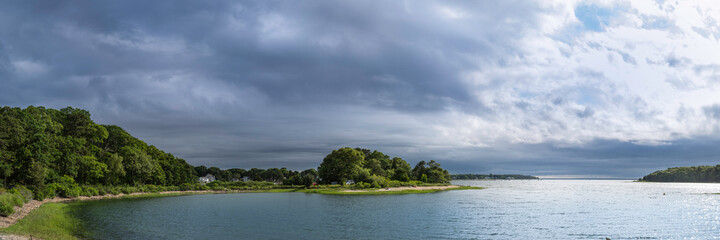 Fototapeta na wymiar Panoramic seascape with views of islands under dramatic stormy clouds. Tranquil cove at Monk Park in Bourne, Massachusetts.