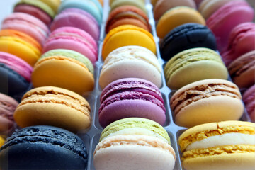 Close up of colorful macaroons, background; bright and colorful cookies laid out in rows. Selective focus