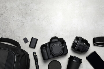Professional photography equipment and backpack on grey stone table, flat lay. Space for text - Powered by Adobe