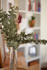 dried eucalyptus branches and thistles in a vase on a table