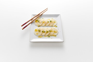 Carpaccio de palmito Pupunha em prato quadrado e hashis