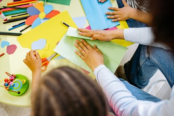 Woman and children doing art with colored papers © Khuong