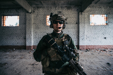Close-up of a professional fully equipped soldier looking at camera.