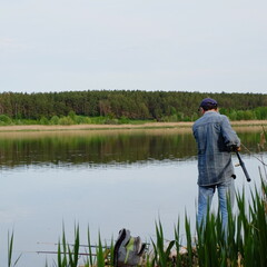 fisherman with a lot of fishing rods on the river in spring