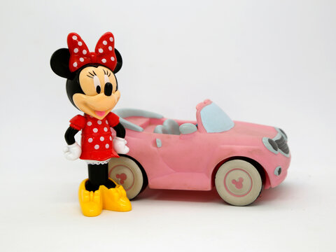 Minnie Mouse and her pink car. Toy. Cartoon character from Walt Disney Pictures Studios. Minnie is Mickey Mouse's girlfriend. Isolated white. Plastic toys for childrens. Doll. Vehicle.